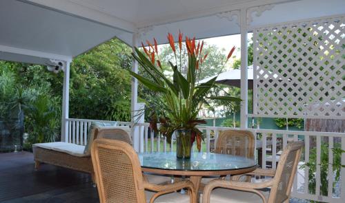 克利夫顿海滩南太平洋住宿加早餐酒店的门廊上摆放着桌椅和盆栽植物