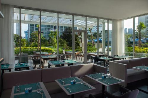 雅加达雅加达塞蒂亚布迪辉盛坊国际公寓的餐厅设有桌椅和大窗户。