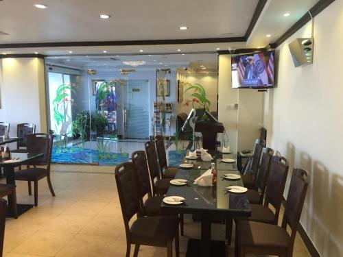 Al KhuwayrīyahReem Hotel Apartments的一间带桌椅和电视的用餐室