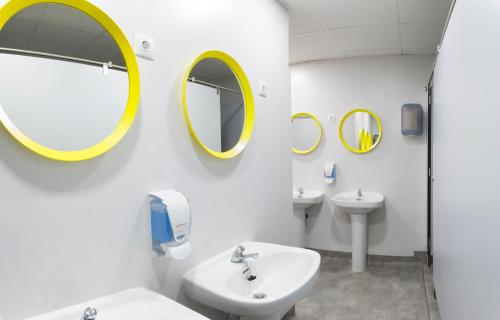 瓦伦西亚UP瓦伦西亚旅舍的一间带水槽和两面镜子的浴室