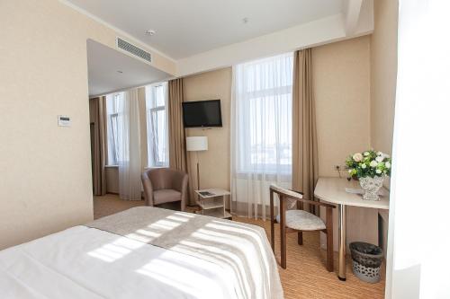 喀山Olymp Kazan的酒店客房配有一张床铺和一张桌子。
