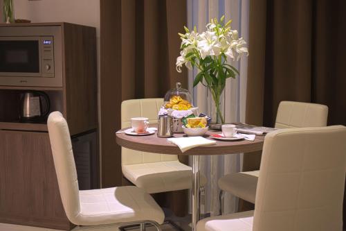 罗马马肯托尼欧酒店的一间带桌椅和鲜花的用餐室