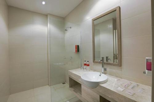 Banjarbarufavehotel Banjarbaru的白色的浴室设有水槽和淋浴。