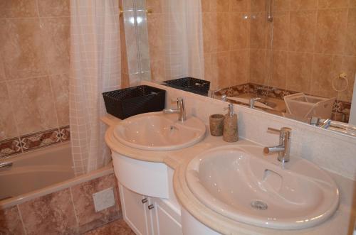 卡斯卡伊斯Alegre Apartamento的浴室配有盥洗盆、浴缸和盥洗盆