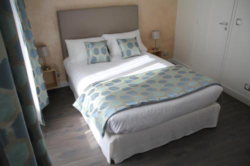 叙雷纳叙雷讷拉德芳斯舒适公寓式酒店的一间卧室配有一张带蓝色枕头的大床