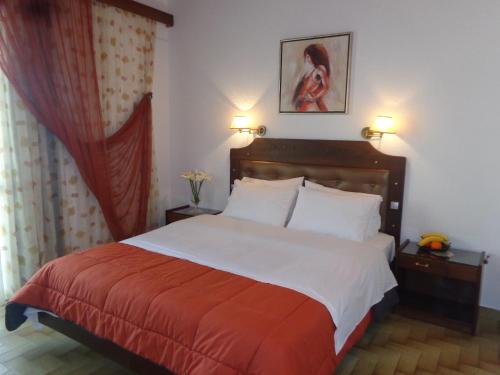 阿吉亚玛丽娜安吉拉酒店的一间卧室配有一张大床,铺有红白毯子