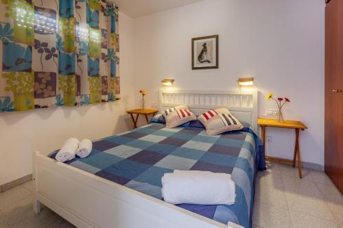 锡切斯锡切斯欧拉公寓酒店的一间卧室配有一张带 ⁇ 子毯子的床