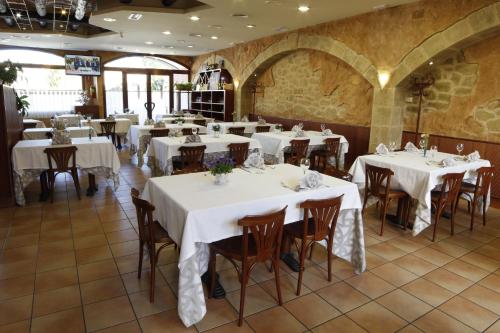 瓦德诺比斯盐酒店的餐厅配有桌椅和白色桌布