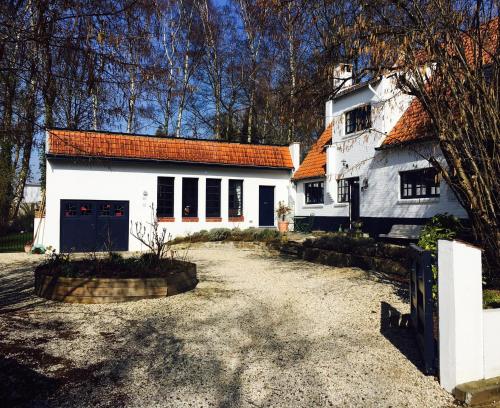 Wezembeek-Oppem罗斯马克住宿加早餐旅馆的白色的房子,有橙色的屋顶和车道