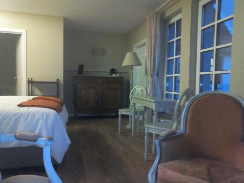 Wezembeek-Oppem罗斯马克住宿加早餐旅馆的一间卧室配有一张床、一把椅子和窗户。