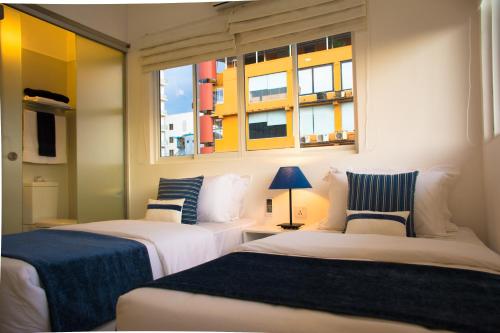 科伦坡住宅酒店的带2扇窗户的客房内的2张床