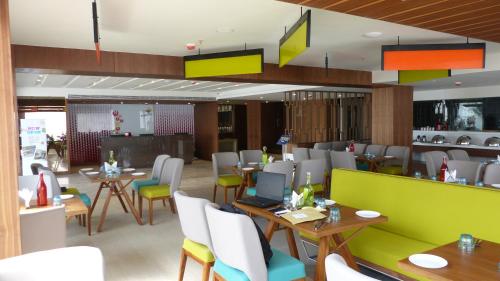 哥印拜陀ZIBE Coimbatore by GRT Hotels的用餐室配有桌椅和脚 ⁇ 