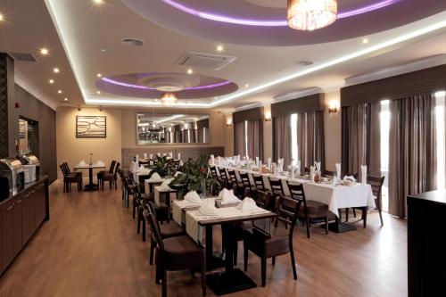 比亚韦斯托克白银酒店的一间设有桌椅和紫色天花板的用餐室