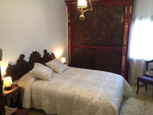 ApiésCasa Justo的一间卧室配有一张大床和木制床头板