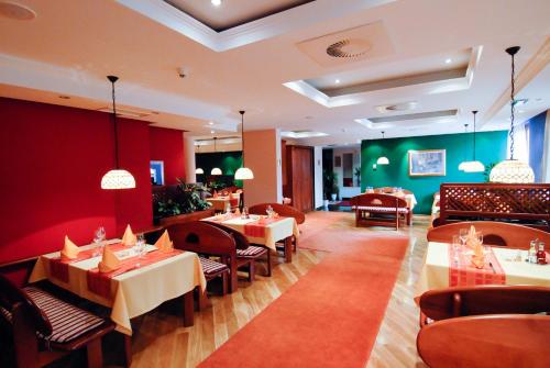萨拉热窝Hotel M3的一间在房间内配有桌椅的餐厅
