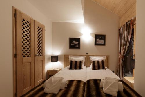 萨莫安斯CGH Résidences & Spas Les Chalets De Laÿssia的一间卧室配有带2个枕头的床