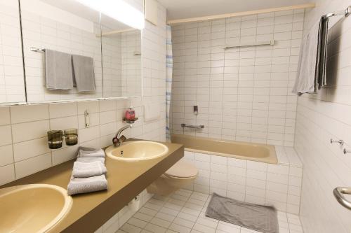 格吕施格鲁施酒店的浴室配有盥洗盆、卫生间和浴缸。