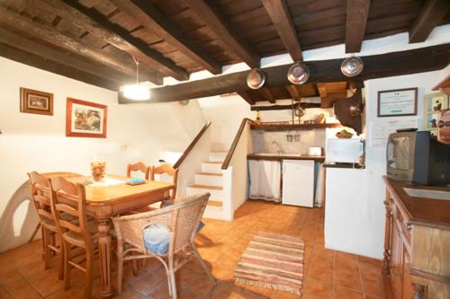 Casas del CastañarCasa Rural La Cueva的厨房以及带桌椅的用餐室。