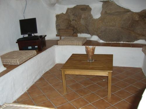 Casas del CastañarCasa Rural La Cueva的客厅配有桌子和电视