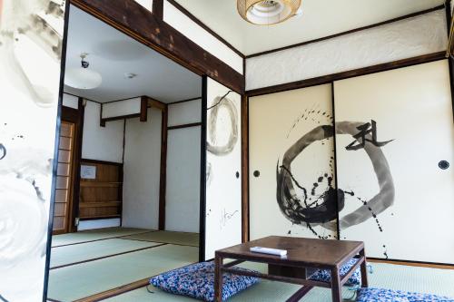 奈良奥库旅馆的一间房间,配有一张桌子和一幅墙上的鸟画