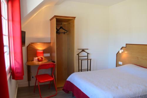 萨尔特河畔勒梅勒安妮科斯酒店的一间卧室配有一张床和一张带红色椅子的桌子
