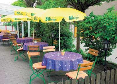 鲁塔希拉姆酒店的一组桌椅,配有紫色桌子和雨伞