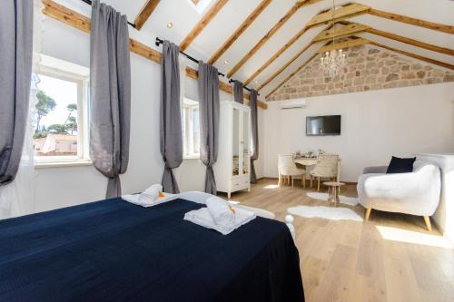 杜布罗夫尼克Dubrovnik Finest Apartments的一间带蓝色床的卧室和一间客厅