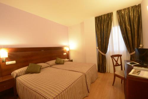 索里亚Hotel Campos de Castilla的酒店客房,配有床和电视