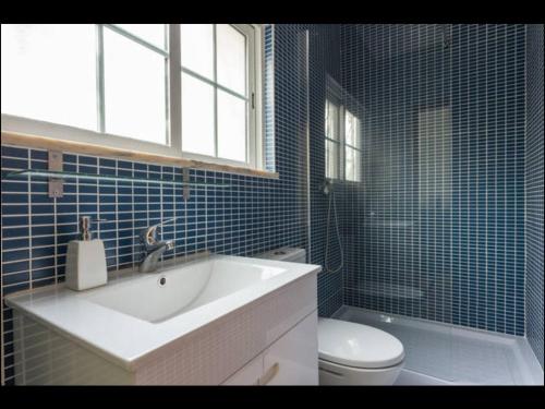 珀彻斯Villa Vilamar的蓝色瓷砖浴室设有水槽和卫生间