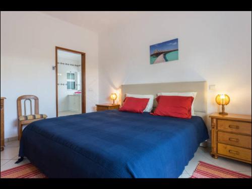 珀彻斯Villa Vilamar的一间卧室配有蓝色的床和两个红色枕头