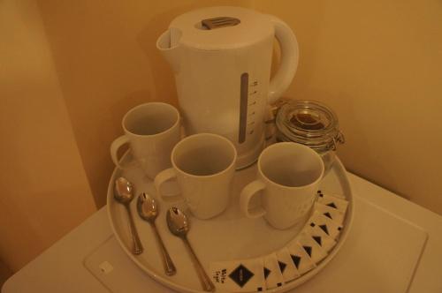 伦敦伦敦蓝宝石酒店的桌子上装有杯子和勺子的托盘