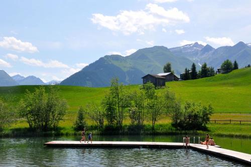 VellaCASA LUMNEZIA - Panoramic Ecodesign Apartment Obersaxen - Val Lumnezia I Vella - Vignogn I near Laax Flims I 5 Swiss stars rating的湖上码头上的一群人