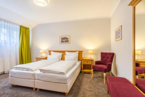 巴特迪克海姆Hotel Annaberg的一间卧室配有两张床和红色椅子