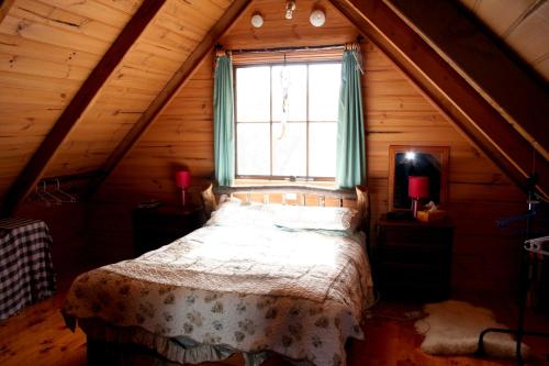 MoinaWombat Cabin的阁楼上的卧室设有一张床,设有窗户