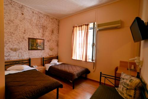 比雷埃夫斯伊莱克特拉比雷埃夫斯酒店的小房间设有两张床和窗户