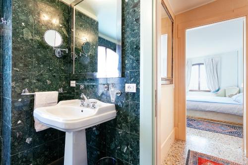 威尼斯泻湖景豪华公寓酒店的一间带水槽和镜子的浴室