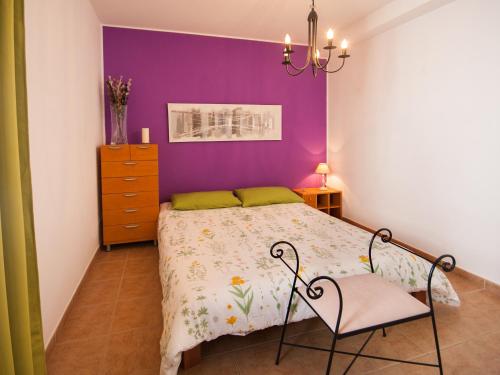 特吉塞Casa Claudia的一间卧室配有一张紫色墙壁的床