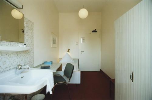 慕尼黑杰德曼旅店的浴室设有白色水槽和镜子