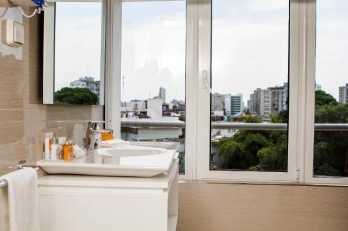 马普托Montebelo Girassol Maputo Hotel的一间带水槽和大窗户的浴室