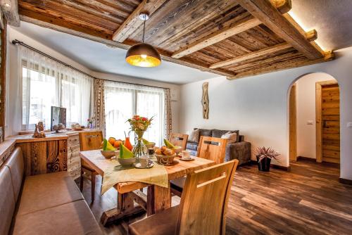 圣维吉利奥Alpine Mountain Chalet的厨房以及带木桌的起居室。