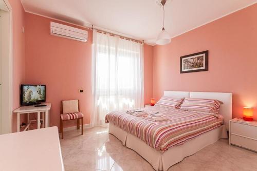 卡利亚里B&B Mareya的卧室设有粉红色的墙壁和一张大床