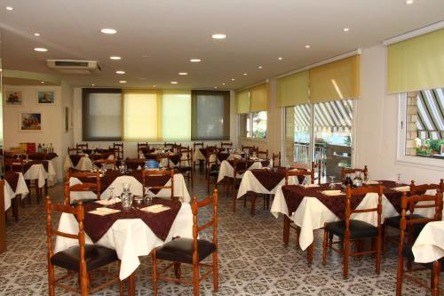 丽都迪萨维奥普利姆拉酒店的餐厅配有桌椅和白色桌布