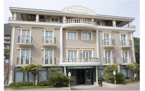 圣乔瓦尼·罗通多Ariae Dépendance - Alihotels的一座带阳台和棕榈树的大型白色建筑