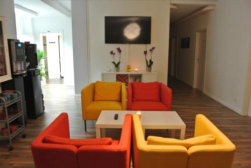 汉堡MAC城市旅舍的客厅配有五颜六色的椅子和桌子