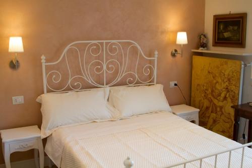 里米尼艾普罗普雷圣吉罗拉莫住宿加早餐旅馆的卧室配有一张白色床、两张桌子和两盏灯。