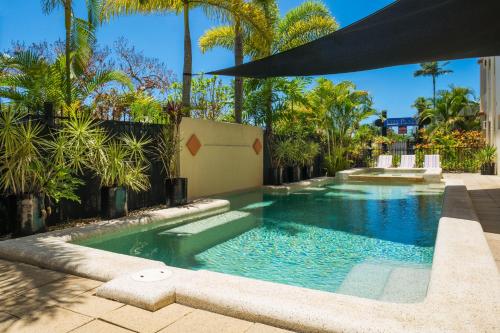 凯恩斯城市广场酒店式公寓的棕榈树庭院内的游泳池