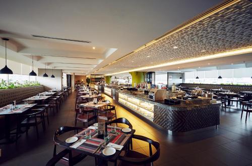 马六甲雅胜酒店的一间带桌椅的餐厅和一间酒吧