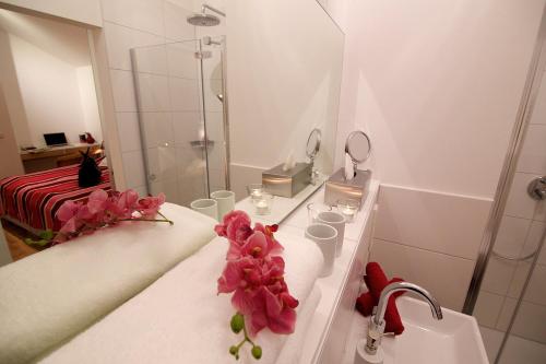 雷根斯堡Ferienwohnung "Karmeliten Am Dom"的浴室设有水槽和鲜花淋浴。