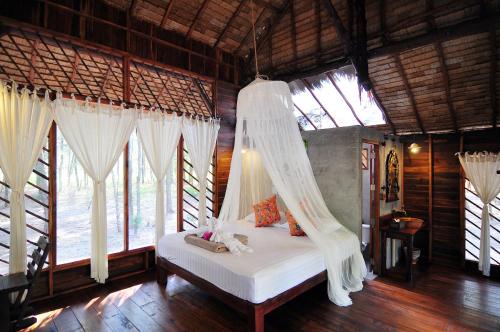 Ko Phra ThongThe Moken Eco Village - SHA plus的一间卧室配有一张带蚊帐的床