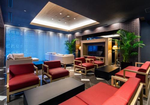 北九州小仓站前大和鲁内酒店的一间设有红色椅子和电视的等候室
